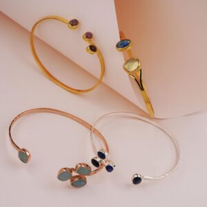 Stylish gemstone bracelets elegantly displayed on a pastel pink backdrop, highlighting luxury and elegance.